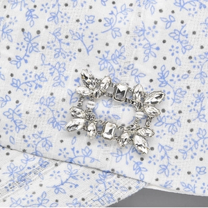 Elegant rectangular rhinestone buckle with teardrop crystals on floral fabric background