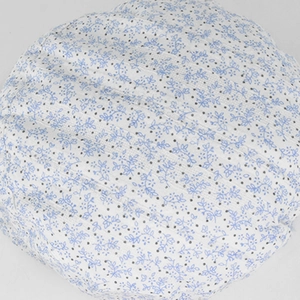 Detailed close-up of blue floral and gray polka dot patterns on white breathable fabric