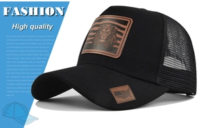 Detail of black trucker hat with leather lion patch and American flag visor tag