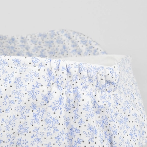 Detail of elastic waistband on white floral print shorts with blue flowers and dots