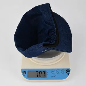 Detailed view of dark blue denim flat top hat on a scale weighing approximately 70.7 grams