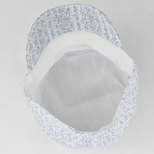 Detailed inner view of blue floral flat top hat showing white lining and fine stitching
