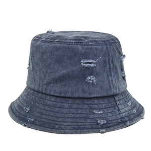 Detail of distressed navy denim bucket hat with frayed holes and vintage washed finish