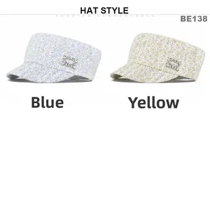 Detailed view of floral flat top caps with rhinestone buckles in blue and yellow colors