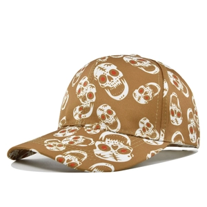 Detailed close-up of khaki baseball cap with white skull print and red eye accents