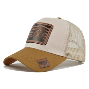 Close-up of trucker hat showing lion leather patch and breathable khaki mesh details