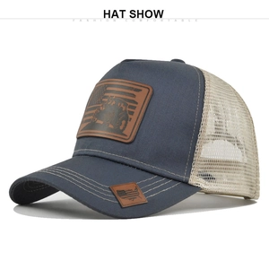 Detail of vintage navy trucker hat featuring leather patches with tractor and flag designs