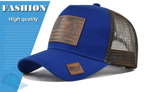 Dettaglio del cappellino trucker blu con rete e patch in pelle bandiera americana