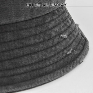Macro detail of washed dark grey canvas bucket hat with frayed holes and stitched brim