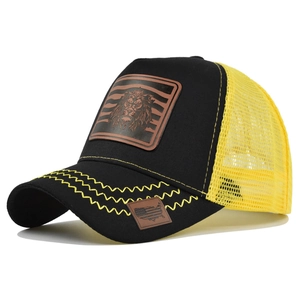 Detail of the lion leather patch and yellow wavy stitching on the black trucker hat