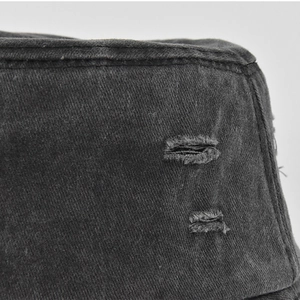 Macro detail of distressed washed canvas bucket hat with frayed rip and vintage texture