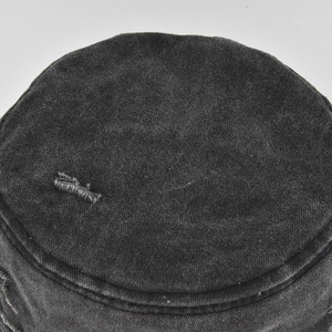 Detail of distressed hole design on a washed dark gray canvas bucket sun hat