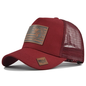 Dettaglio della toppa in pelle con pesce in rilievo sul cappello trucker bordeaux