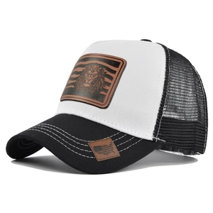 Detailed close-up of brown leather lion patch on the mesh trucker baseball cap