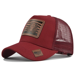 Detail of burgundy mesh trucker hat featuring a lion leather patch and breathable net