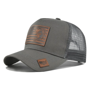 Dettaglio del cappello trucker con patch bass bandiera USA e rete traspirante