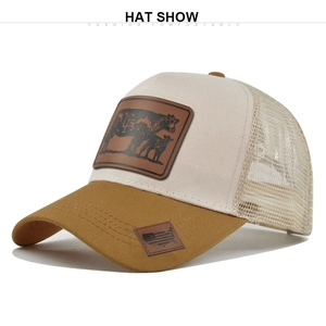 Detailed view of cream and brown trucker hat featuring leather cow patch and mesh back