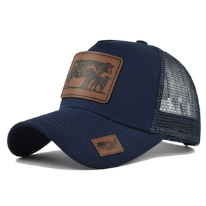 Detailed view of navy mesh trucker hat featuring a cow patch and breathable rear paneling