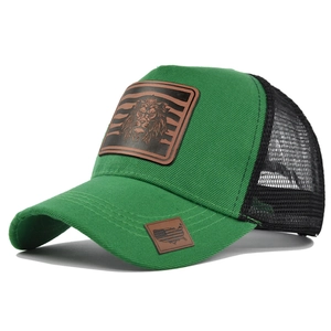 Green and black mesh trucker hat with lion leather patch and flag detail shown in 45-degree angle
