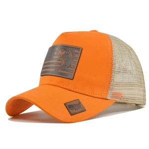Dettaglio del cappello trucker arancione con toppe in pelle, pesce persico e bandiera USA