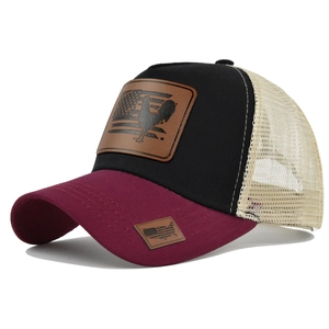 Dettaglio del cappello trucker vintage con patch in pelle di gallo e rete traspirante