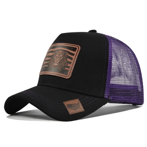 Detail of lion leather patch and purple mesh on black mesh trucker baseball cap