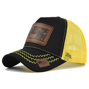 Detailed side view of cow leather patch and yellow mesh back on a black trucker hat