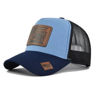 Detail of blue trucker hat featuring brown leather tractor patch and mesh back