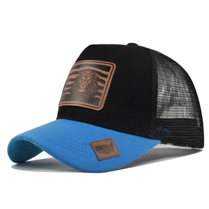Detailed view of the embroidered leather lion patch on a breathable mesh trucker cap