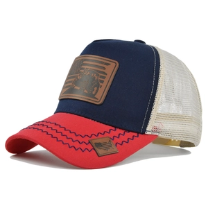 Close-up of tractor leather patch and mesh detail on the red white and blue trucker hat