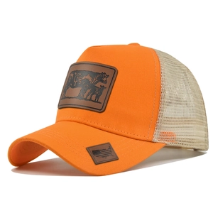 Detail of orange trucker hat showing mesh back and leather cow patch with flag tag
