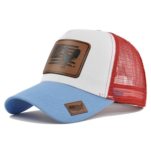 Dettaglio del cappello trucker in mesh rosso bianco blu con toppa in pelle gallo