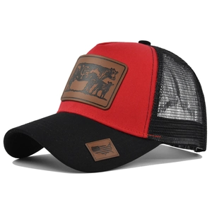 Detail of red and black trucker hat featuring cow leather patches and mesh back