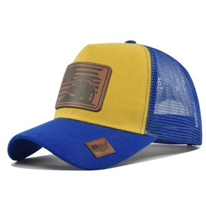 Detail of yellow and blue mesh trucker hat with tractor faux leather patch and curved brim