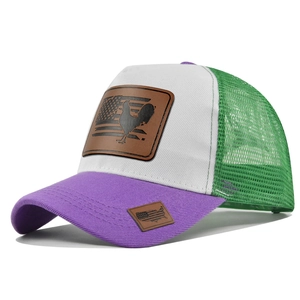 Dettaglio del cappello trucker in rete tricolore con toppa in pelle di gallo sul davanti