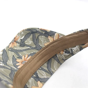 Close-up of floral print visor with multi-row stitching and brown binding detail