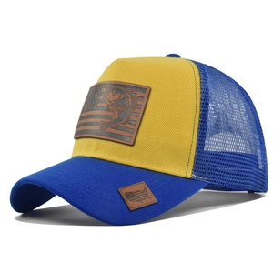 Dettaglio cappello trucker blu e giallo con toppa in pelle di branzino su sfondo bianco