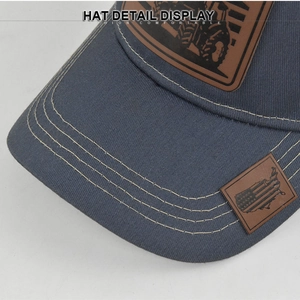 Detail display of tractor leather patch and US map logo on a grey mesh baseball cap