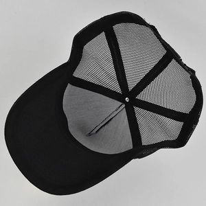 Inside view of a black mesh trucker hat with adjustable plastic strap and metal rivet