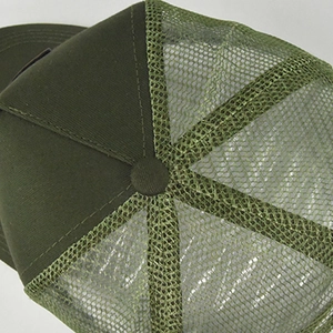 Dettaglio dei pannelli in mesh verde militare e delle cuciture di un cappello trucker