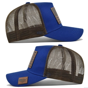 Dettaglio del cappello trucker blu con rete marrone e patch in pelle con bandiera USA