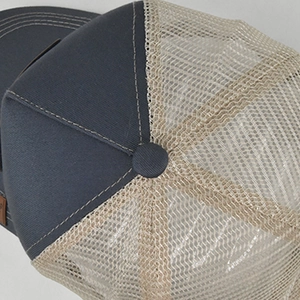 Close-up of canvas stitching and mesh ventilation on a classic mesh trucker cap