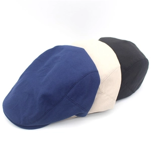 Three classic cotton flat caps in navy, beige and black colors shown from a side profile