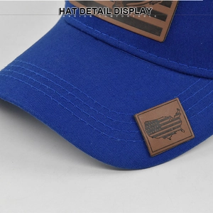 Dettaglio macro del cappellino blu con trama diagonale e toppa in pelle USA