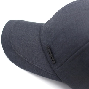 Close-up of metal 'SPORTS' emblem and premium woven texture on charcoal baseball cap