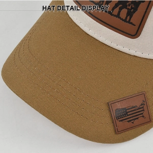 Detail of embroidered American flag leather patch on the brim of a mesh baseball cap