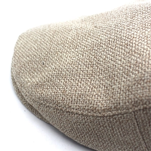 Detail of cross-woven linen texture and curved brim stitching on beige flat cap