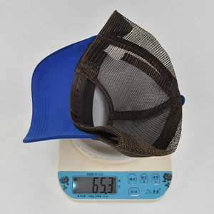 Misurazione dettagliata del peso di un cappellino trucker in mesh blu e marrone da 65,3g