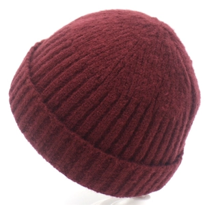 Detail of burgundy ribbed knit beanie showing thick wool texture and folded cuff style