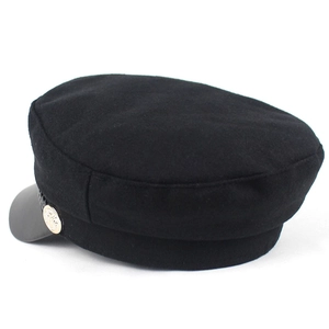 Classic black fiddler cap with leather brim and decorative golden heraldic button